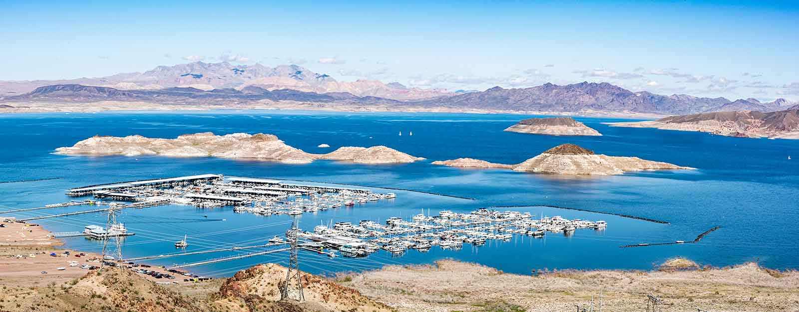 Photography of Boulder Marina at Lake Mead National Park, image shows vivid blue water and sky, along with boat docks and islands gaining ground as the water level decreases.